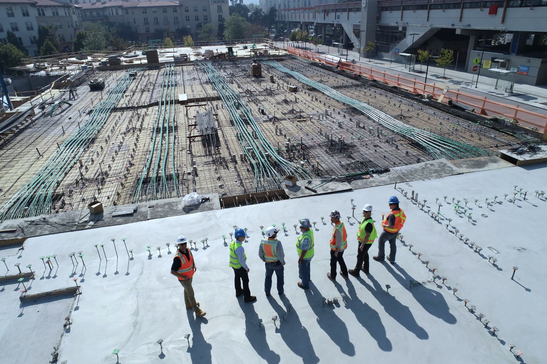 Team walking a construction site above a poured slab